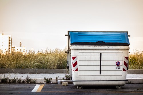 Front view of a commercial waste collection vehicle outside a business in Lee